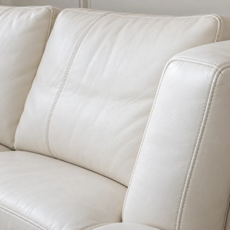 Cream leather back cushion meeting the seat and arm of a sofa