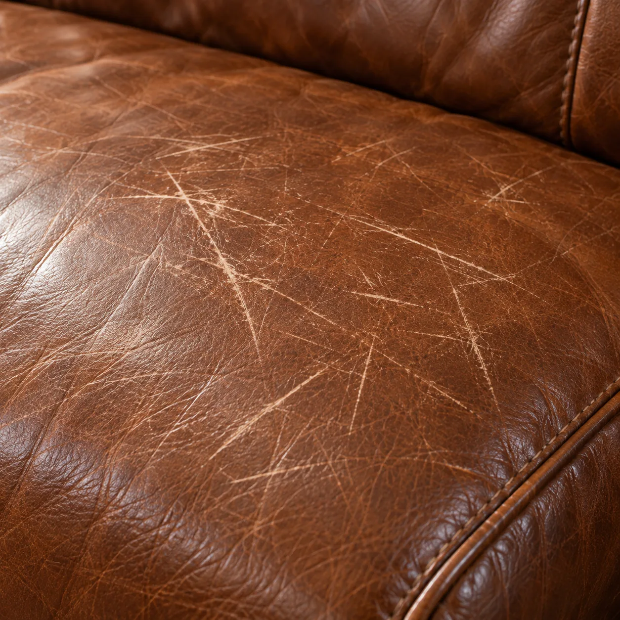 A close photograph of scratches across a leather seat cushion