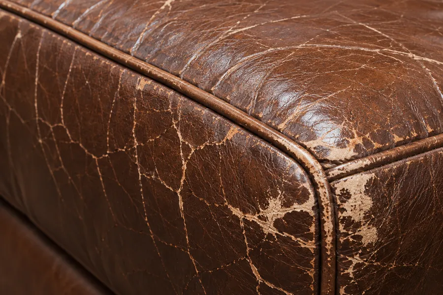 Cracking concentrated along the piped front edge of a leather seat