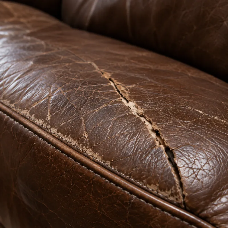 A crack opening along the fold line of a well-used leather seat