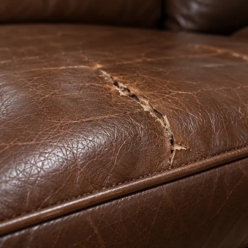 A long split running across the seat of a heavily used leather sofa