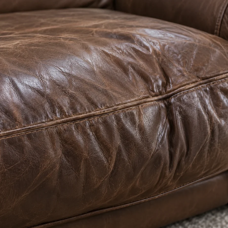 Loose slack upholstery rippling across a brown leather seat cushion