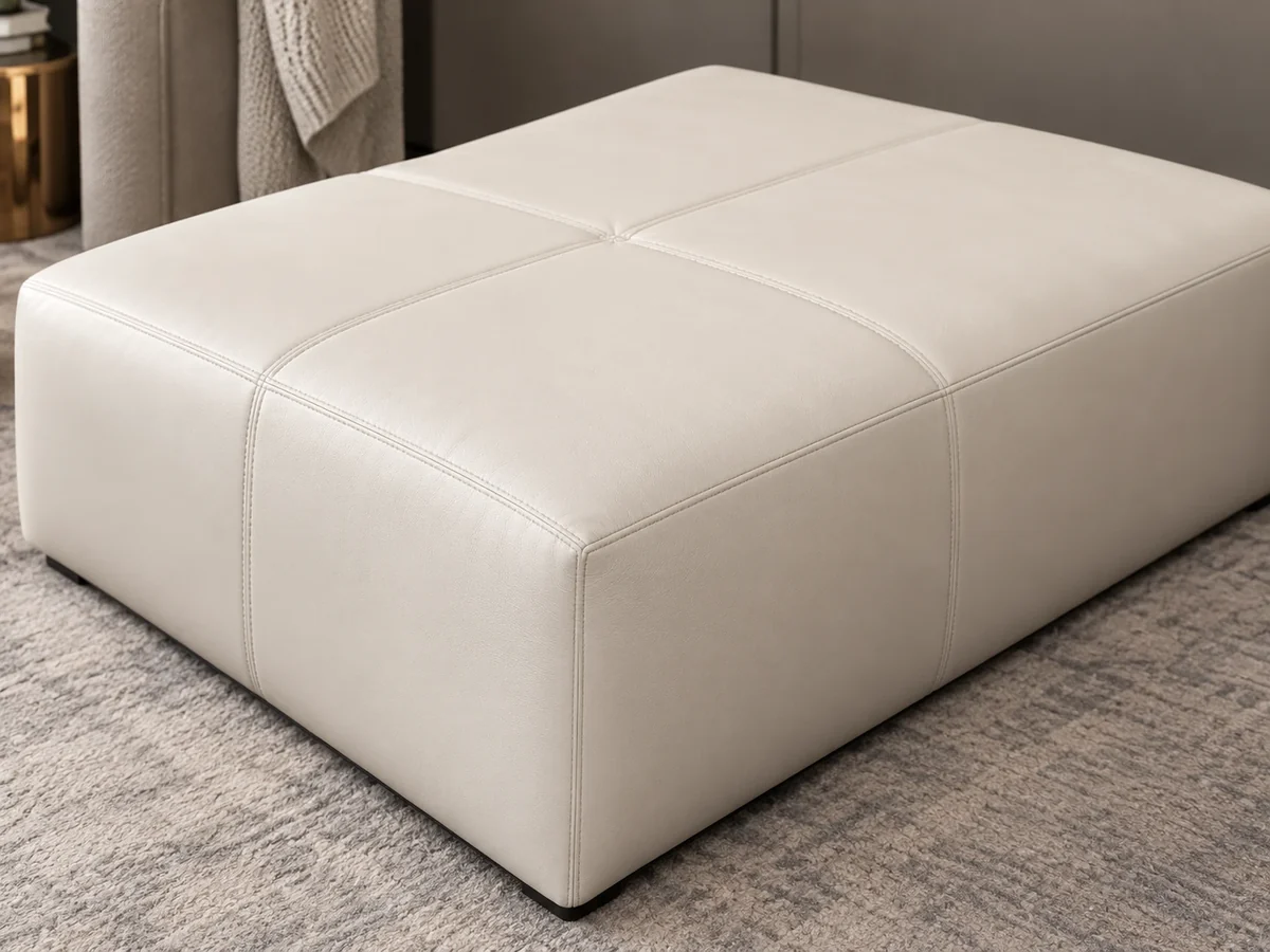 Bone leather ottoman with welted box edges and a panelled top