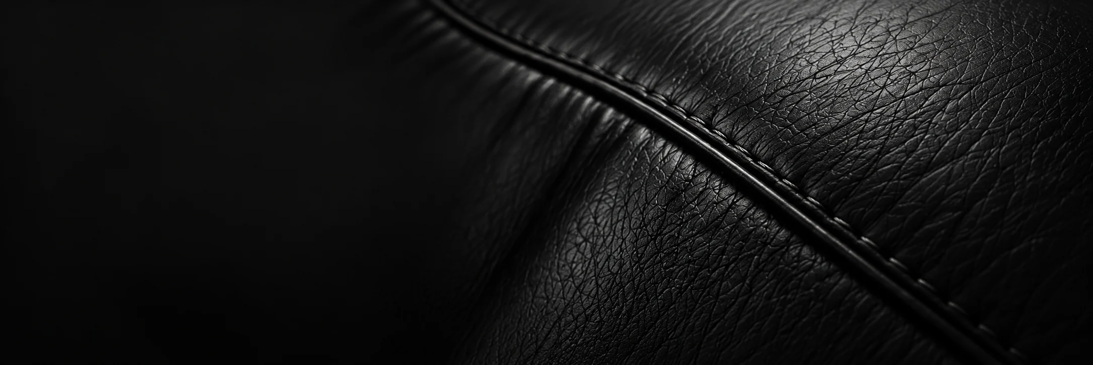 Leather furniture restoration NYC: close view of stitched black leather on a restored seat
