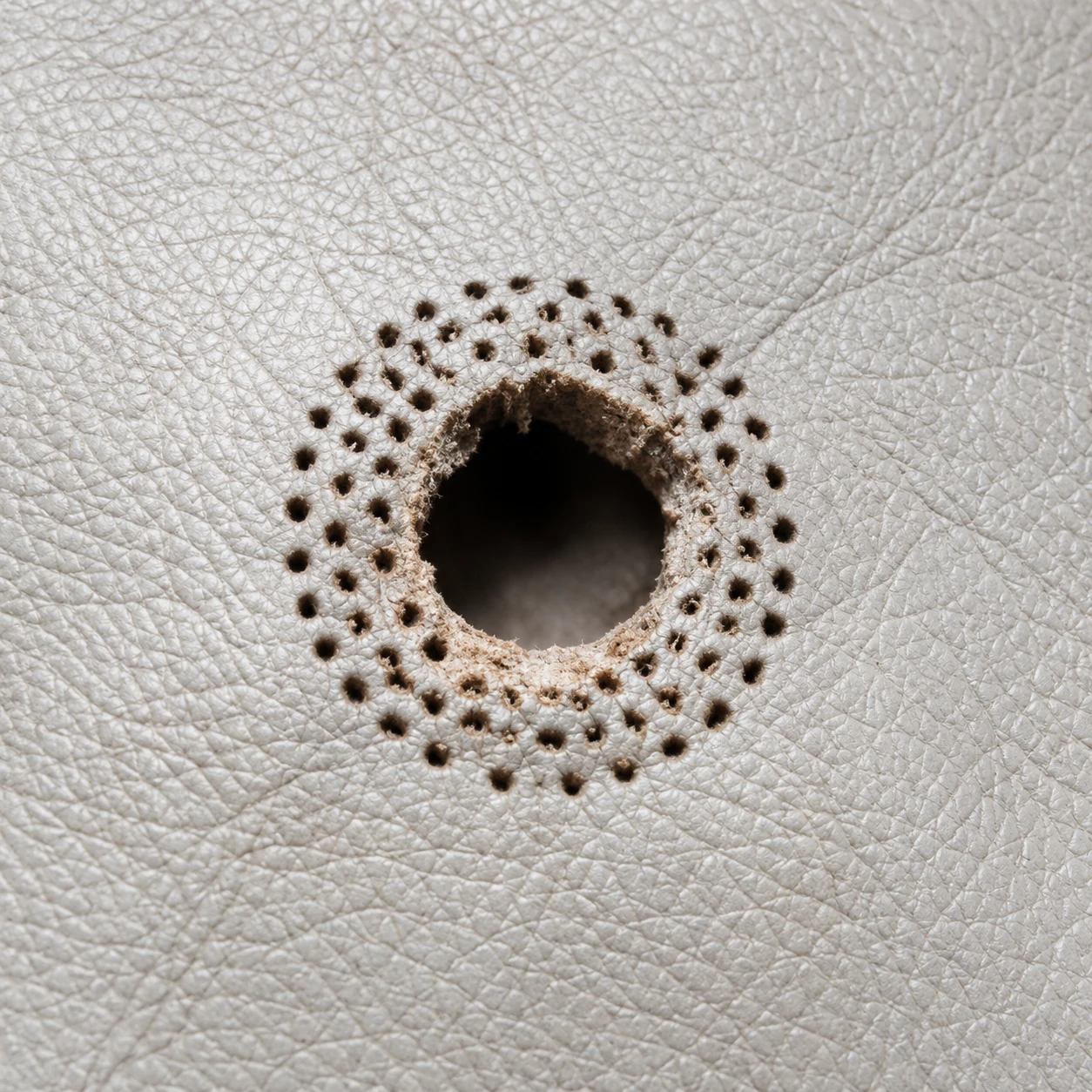 Leather upholstery repair: a round hole worn through cream leather