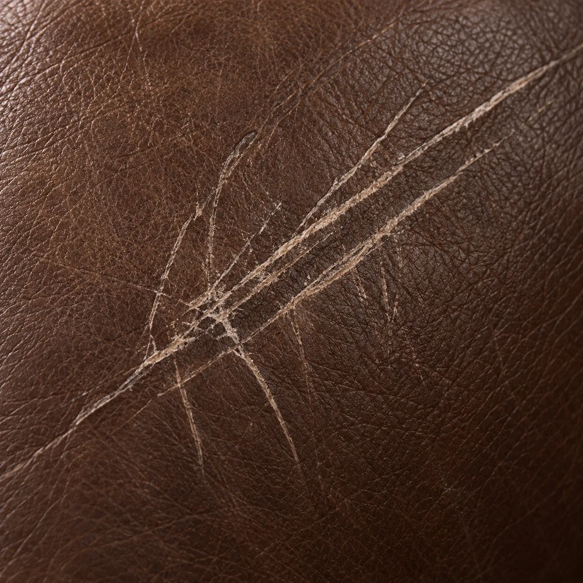 Leather repair NYC: deep scratches across a brown leather surface