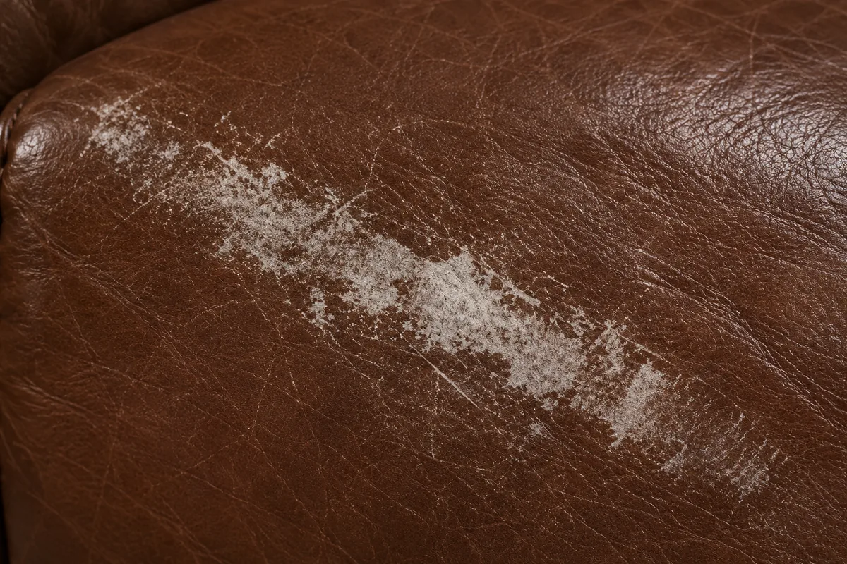 A solid pale band worn across brown leather where the colour has gone