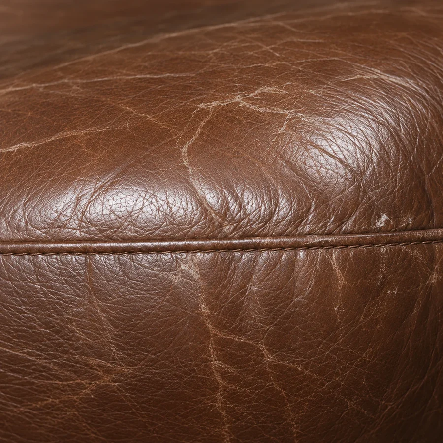 Close-up of a rubbed scuff mark on a brown leather panel