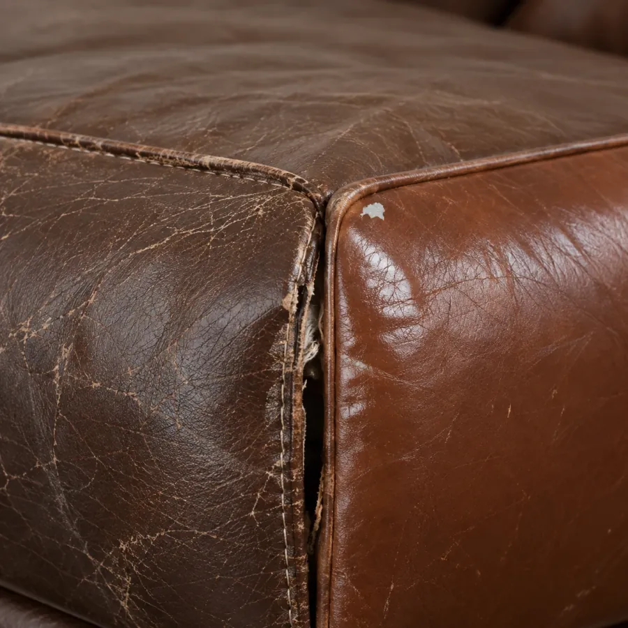 Leather sofa corner where the stitched seam has pulled open