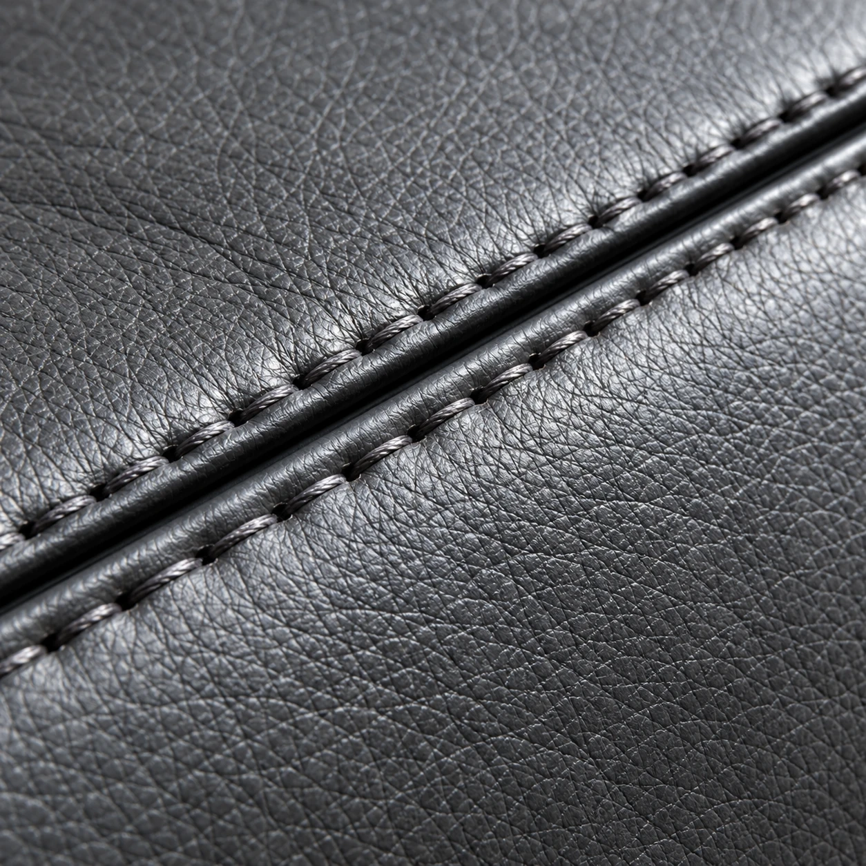 A stitched seam and nailhead trim on dark leather