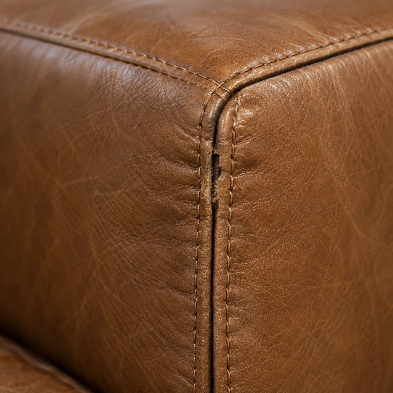 A double-stitched corner seam on a leather sectional