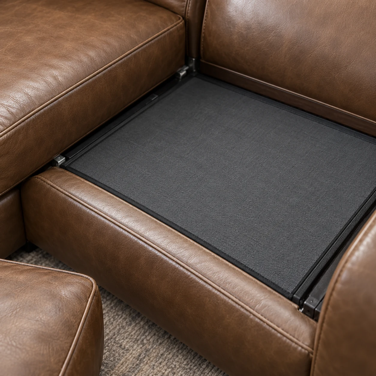 Seat deck of a brown leather sectional with the cushion lifted out