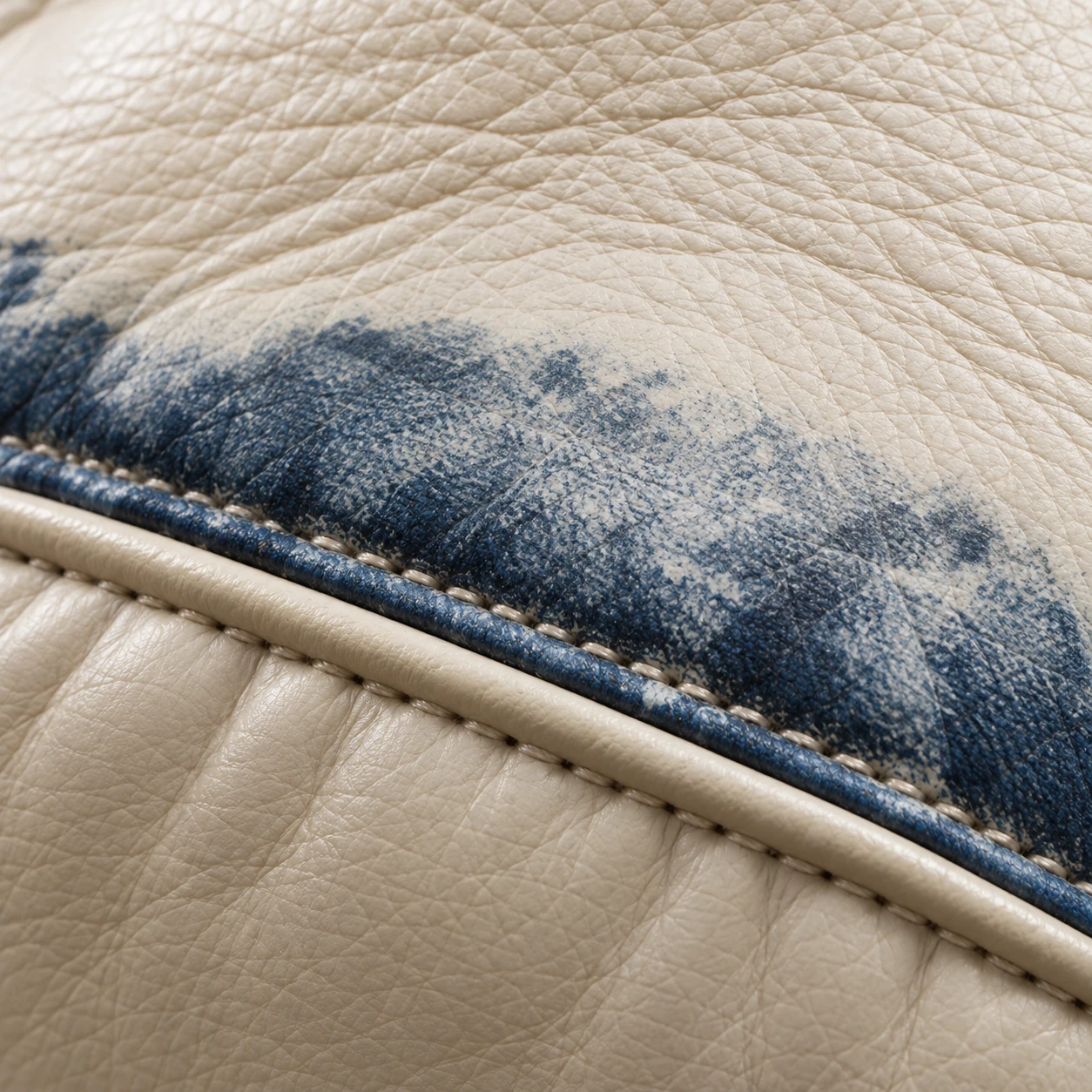 Blue denim dye transferred onto cream leather along the piping