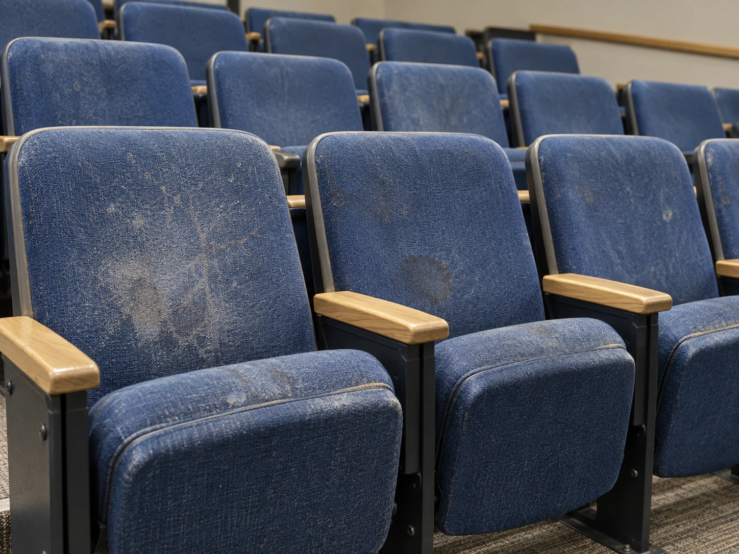 Stained blue lecture hall seats before the work