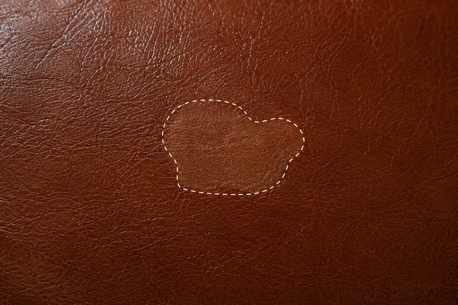 Brown leather where scratching has taken the pigment away, leaving pale lines