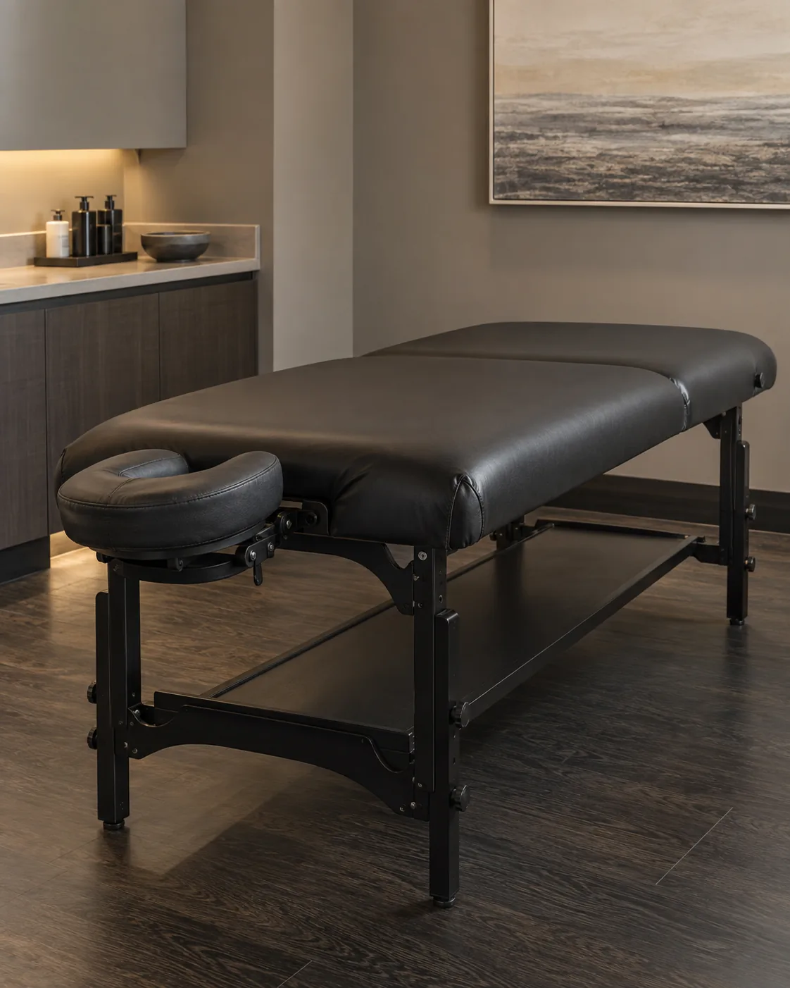 A black vinyl massage table in a spa room