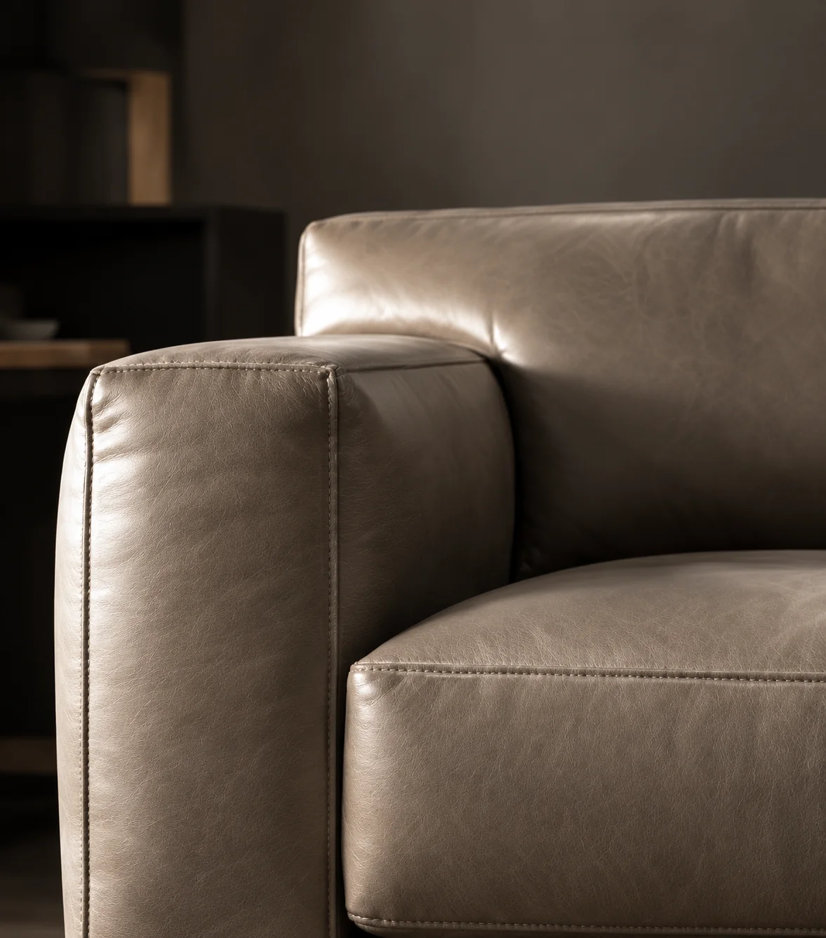 Taupe leather sofa arm with a piped seam