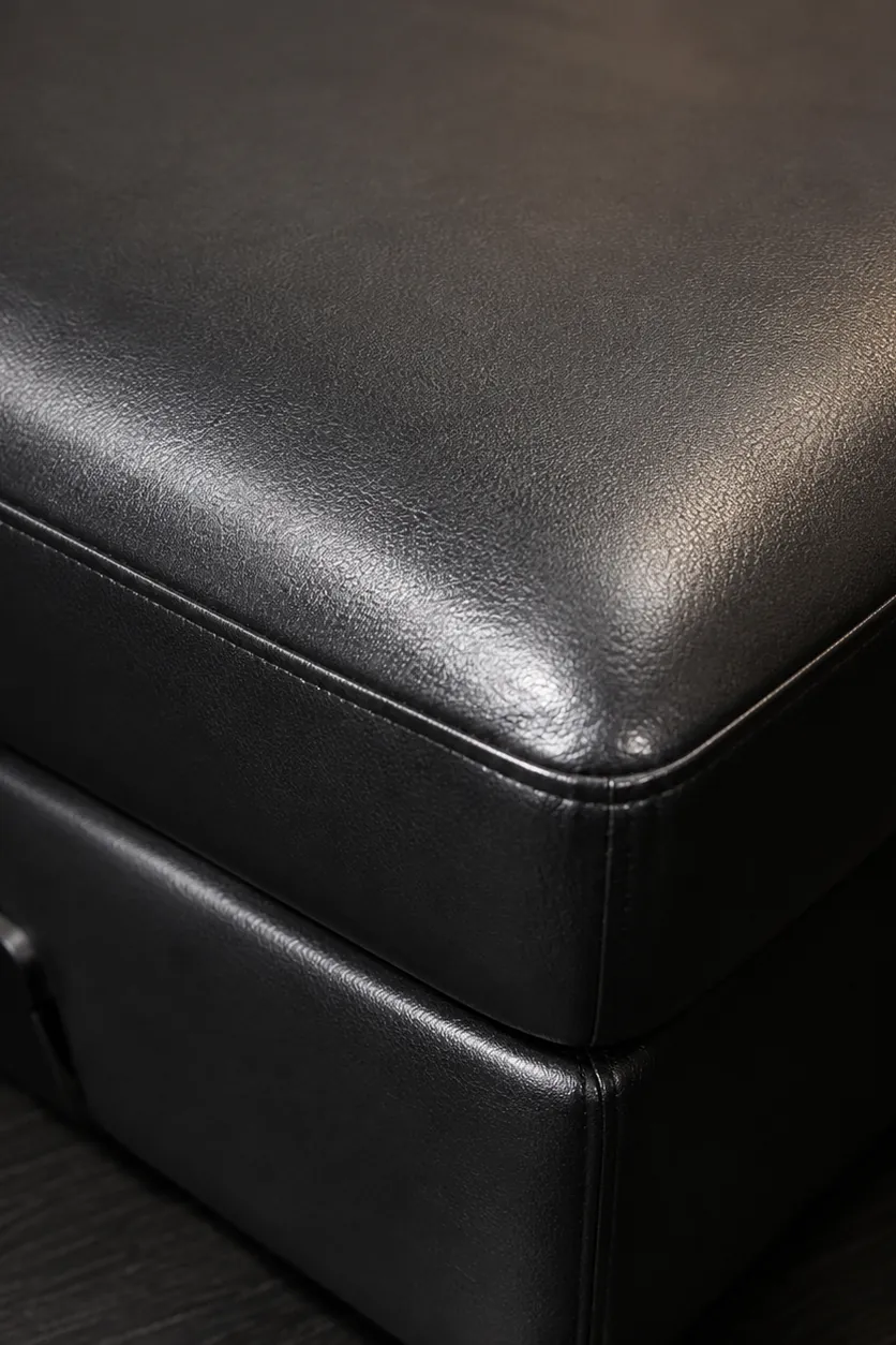 A black commercial vinyl upholstered ottoman corner