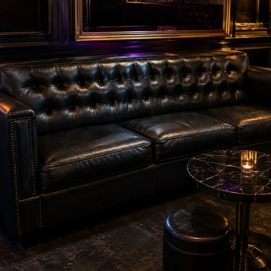 A black tufted chesterfield lounge sofa in a nightclub