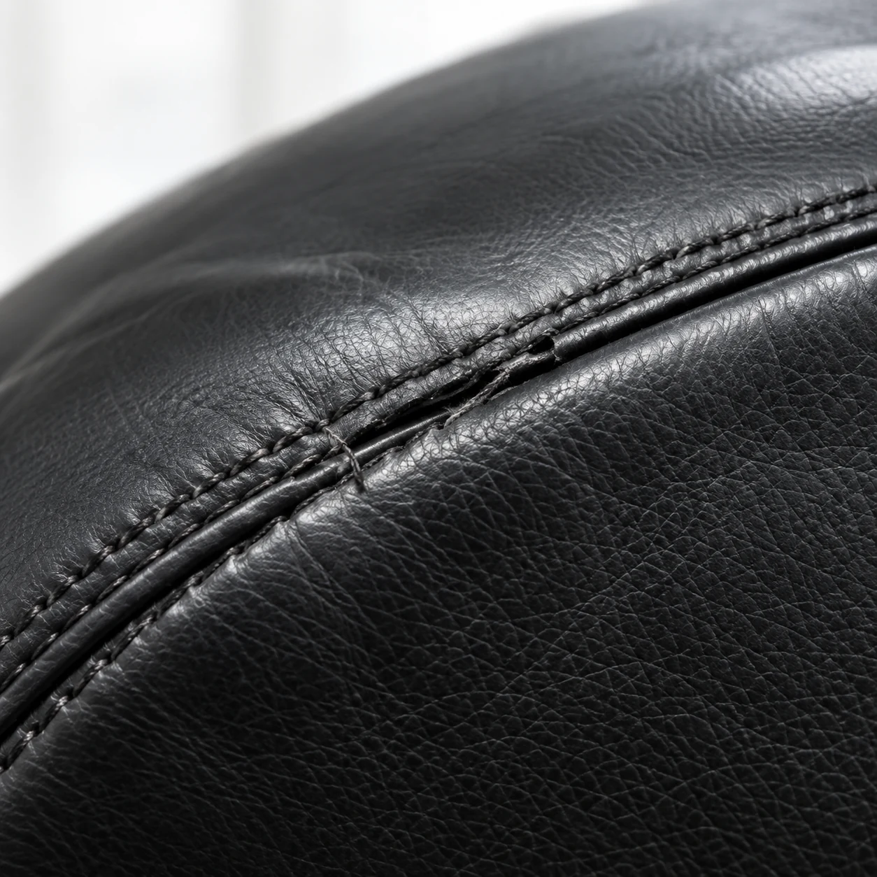 Close view of the stitch line on a black office chair seam