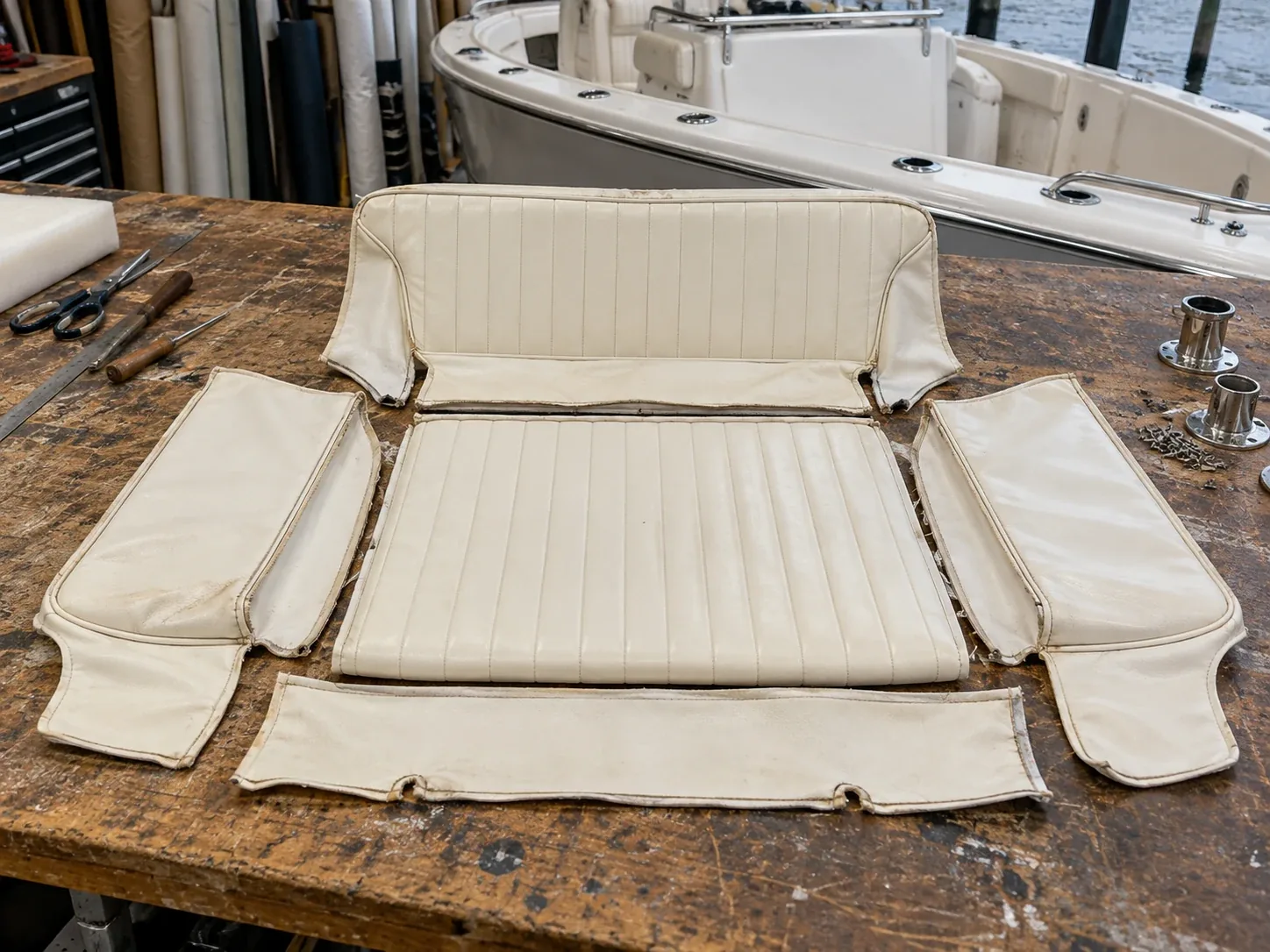 An old boat cushion cover unpicked and opened flat on a bench as a pattern