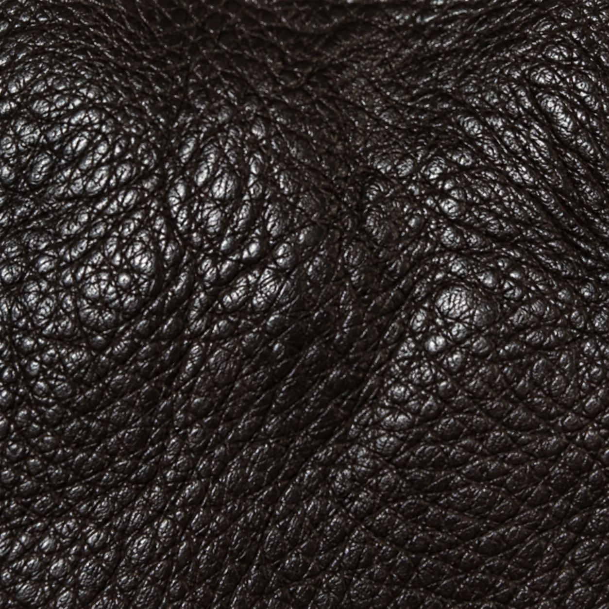 A close view of black pebbled upholstery leather with a raised, rounded grain