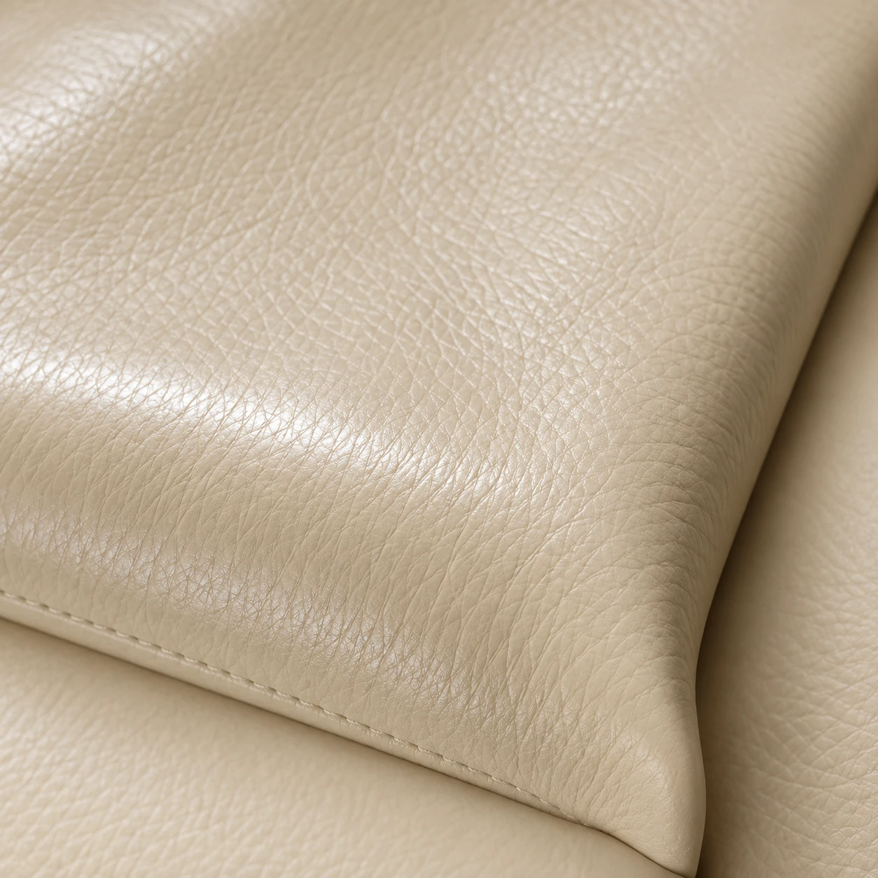 Cream pigmented leather swatch with an even printed grain and a soft surface sheen