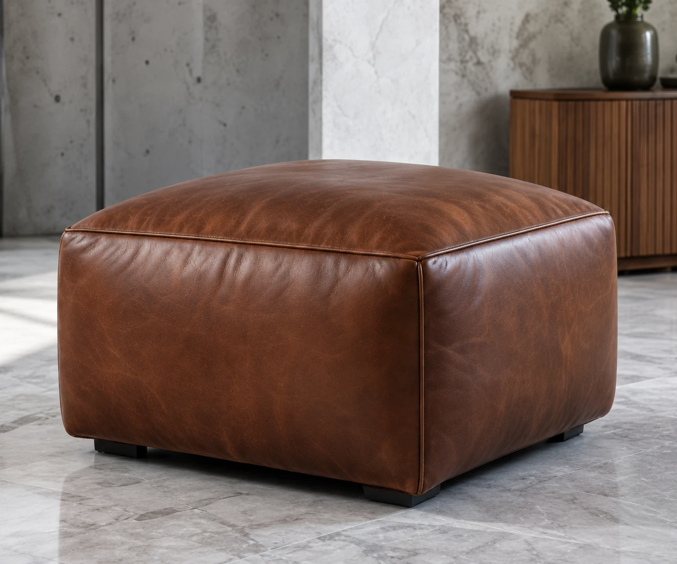 Cognac leather ottoman in front of a fluted walnut credenza