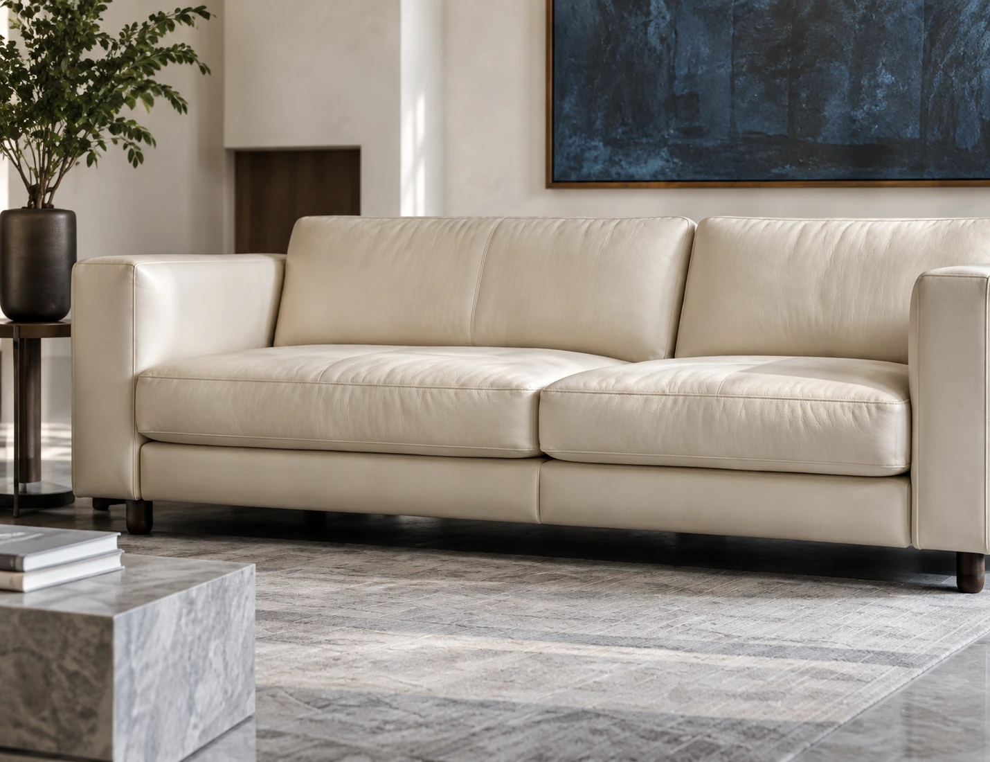 Cream leather sofa in a living room with a dark canvas above it