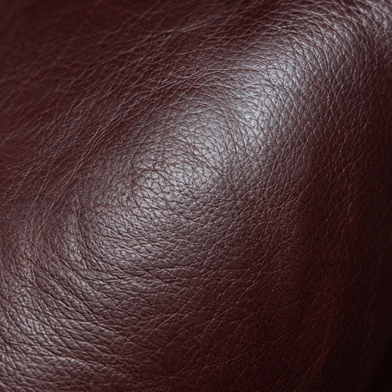 Natural grain variation across deep oxblood leather