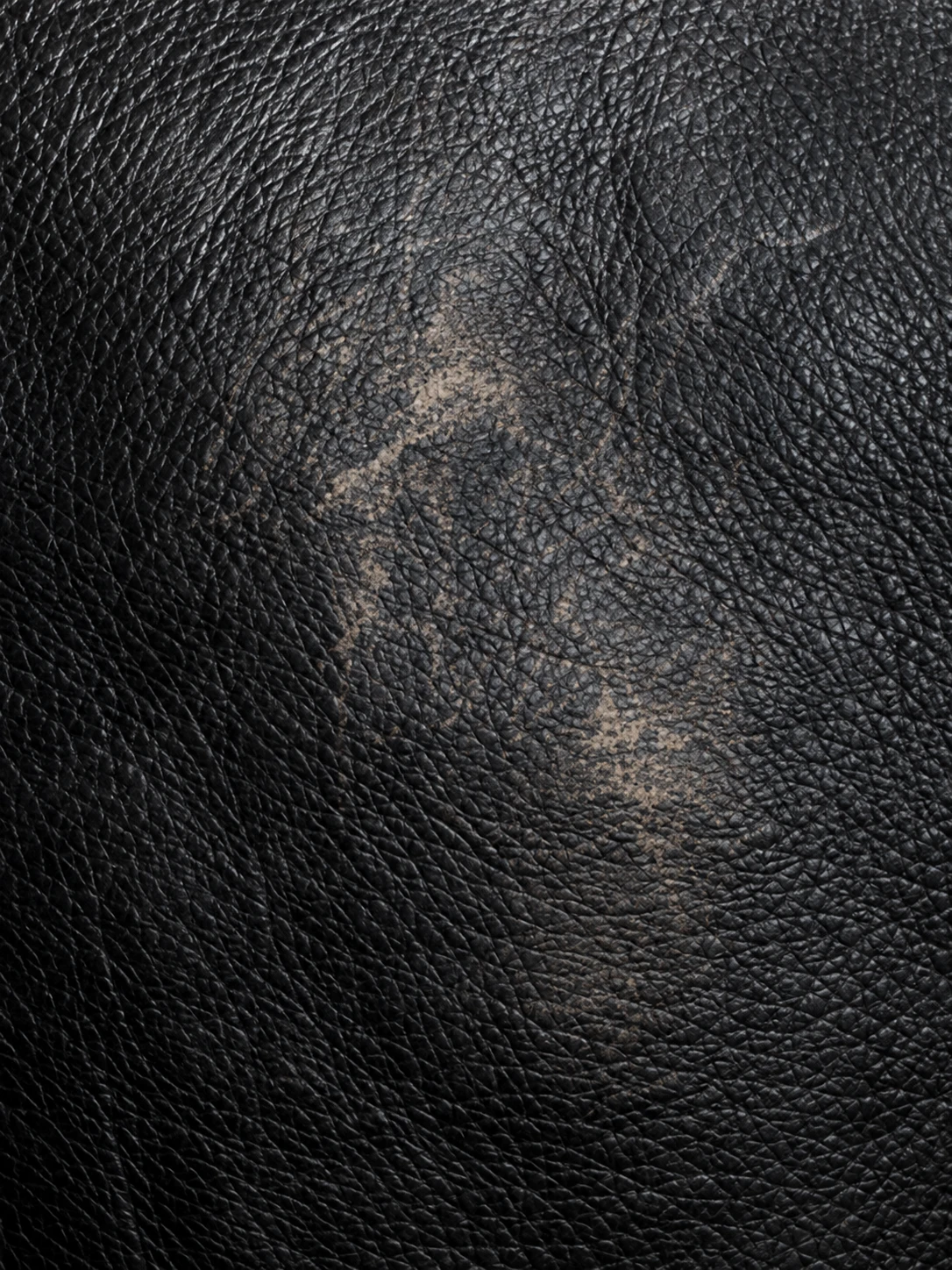 Lighter worn patch in otherwise black leather