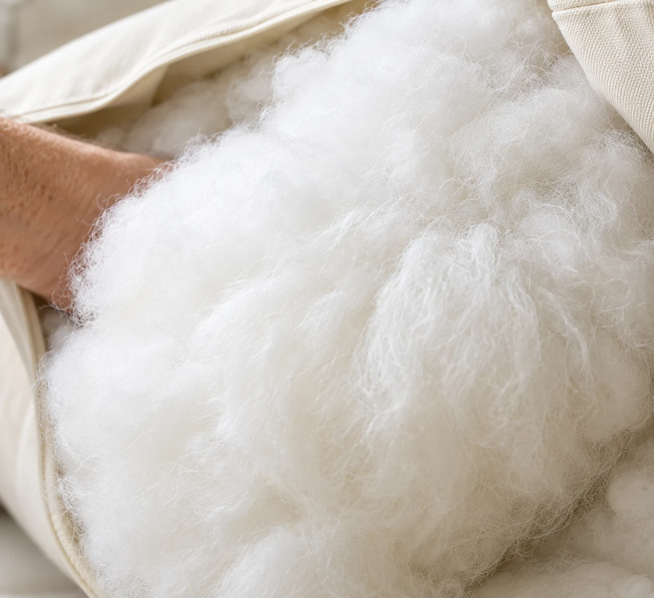 Hand packing white polyester fibre wrap into an outdoor cushion cover