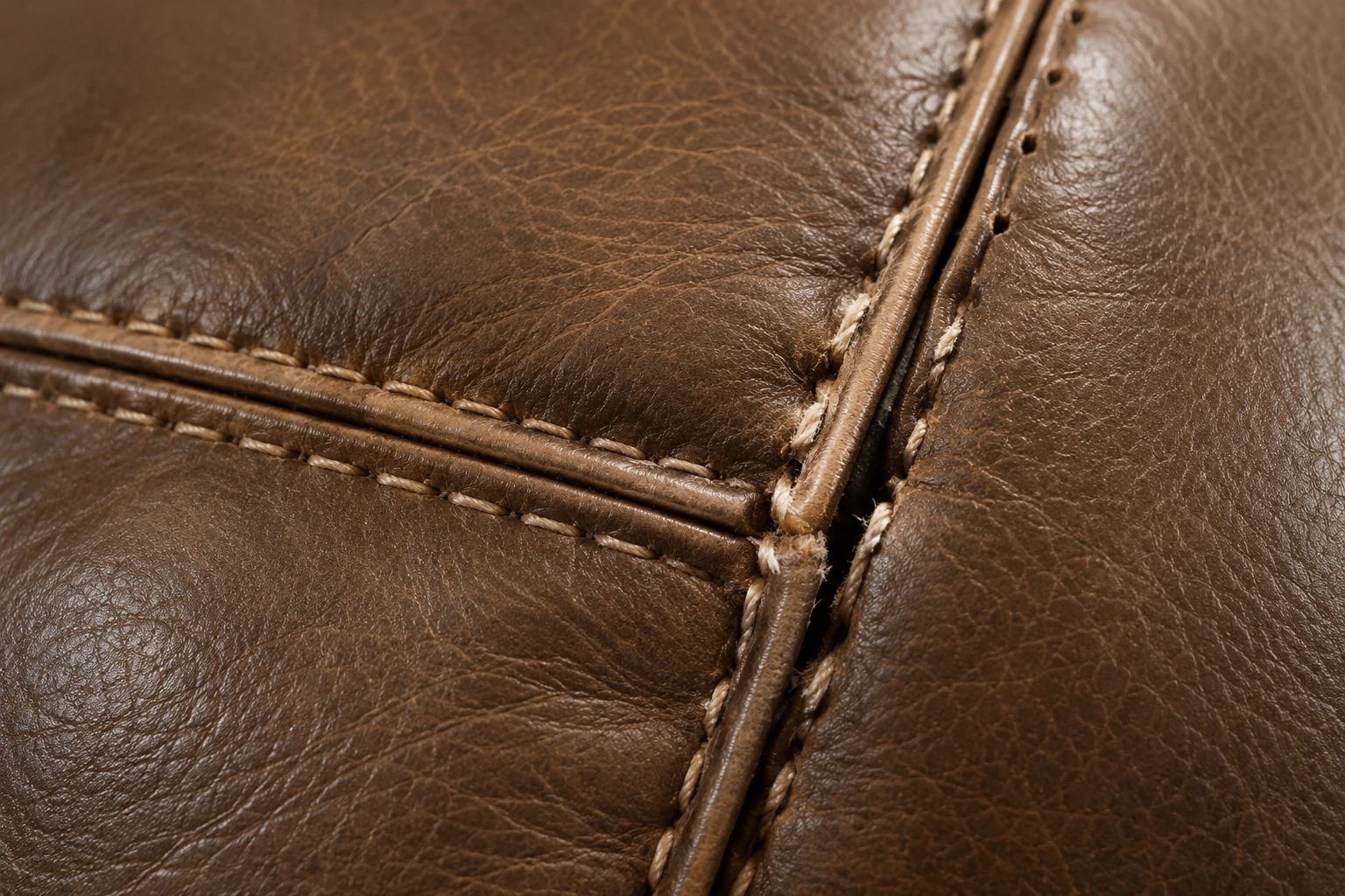 Stitched corner detail on a tan leather recliner seam