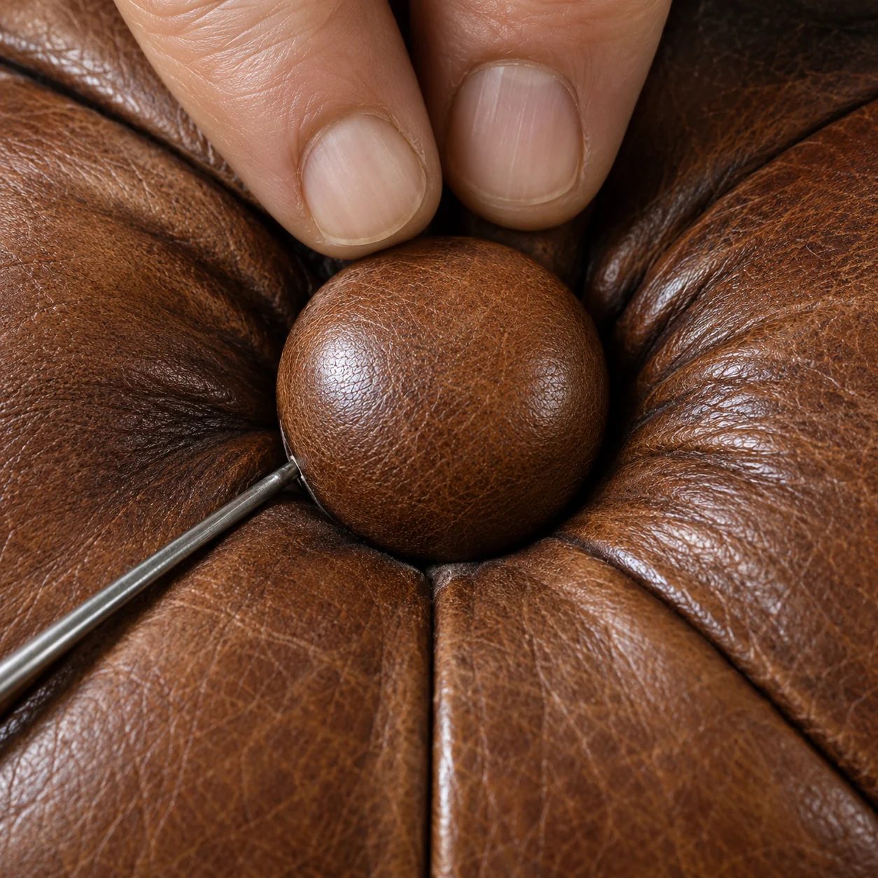 Antique leather furniture restoration Chicago: a deep button re-tied with twine