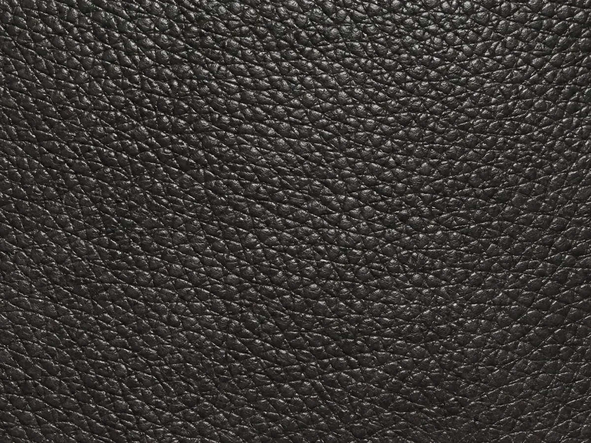 Black upholstery leather with a raised pebble grain that hides scuffs and daily marking