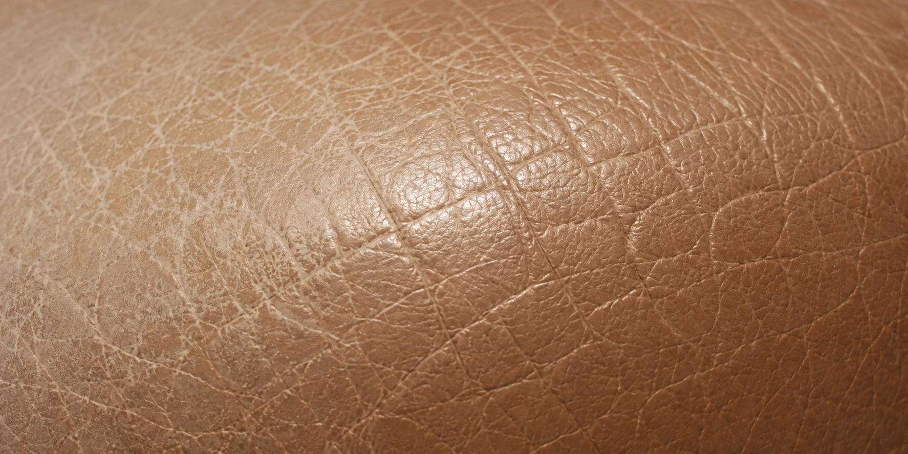 Caramel leather rubbed back to a paler base across a worn area