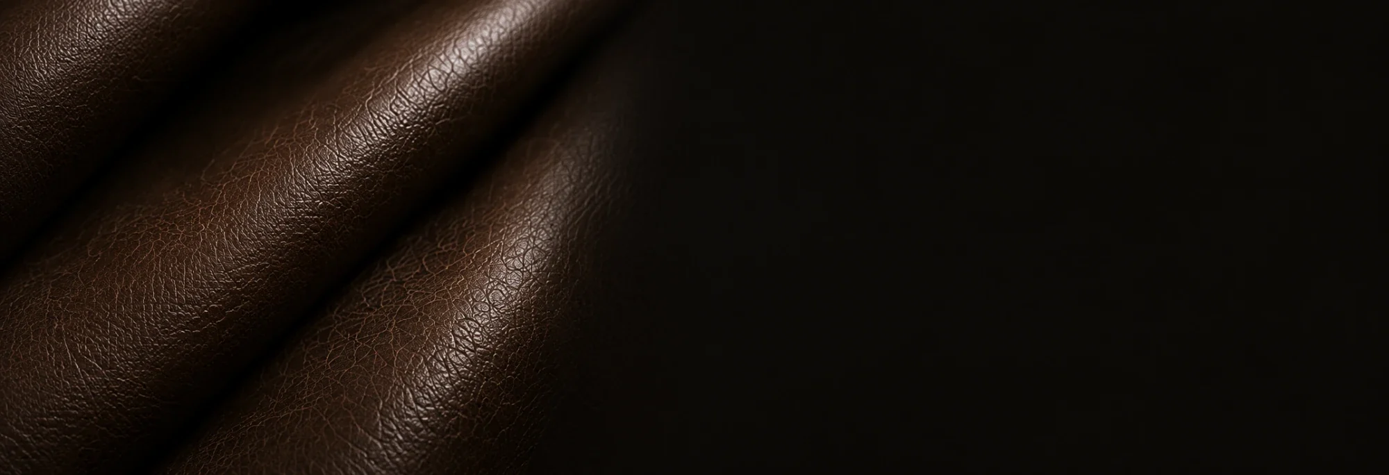 Folded dark brown upholstery leather lit from the side