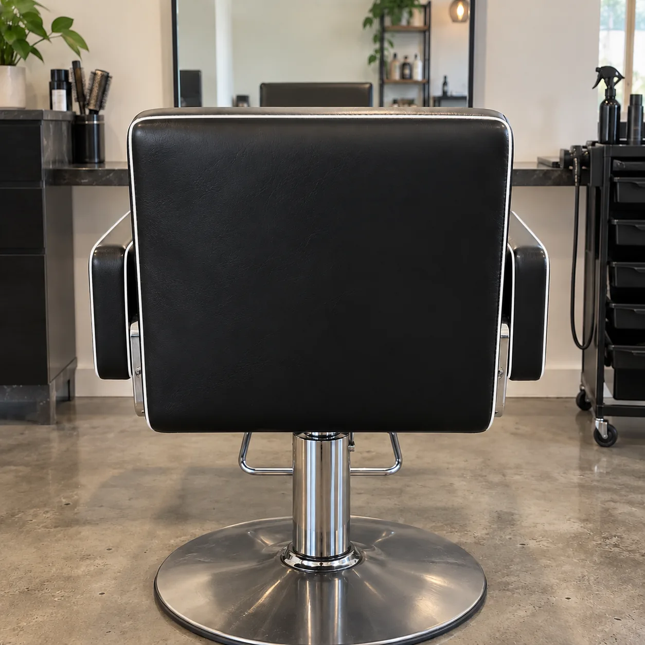 A black styling chair with white contrast piping