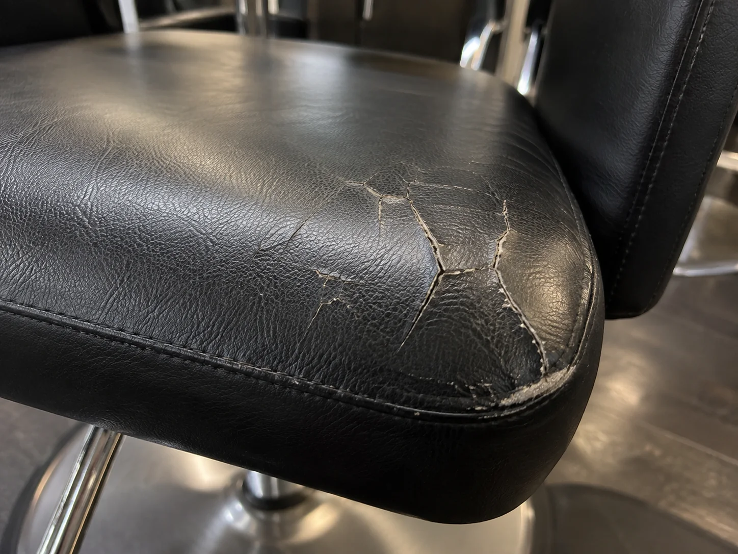 A cracked vinyl edge on a salon chair seat