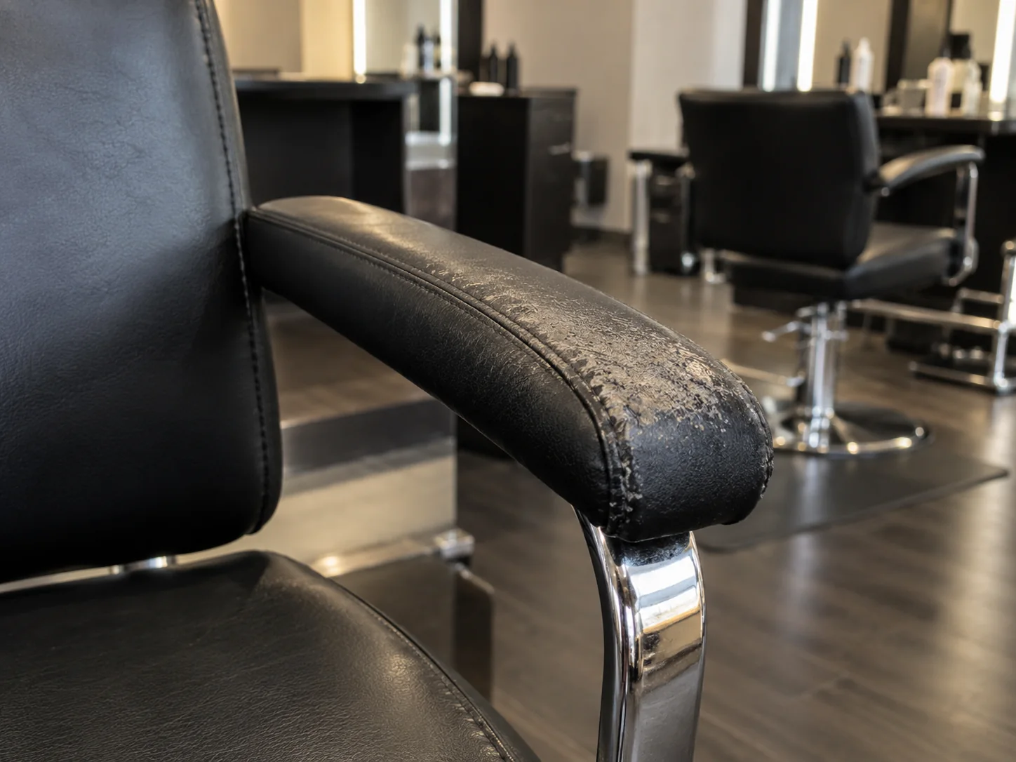 A worn armrest pad on a salon chair
