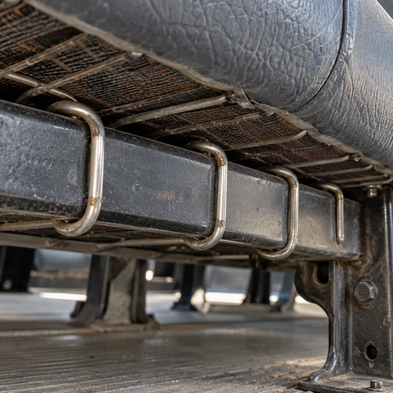Macro of hog rings closed on a school bus seat frame rail
