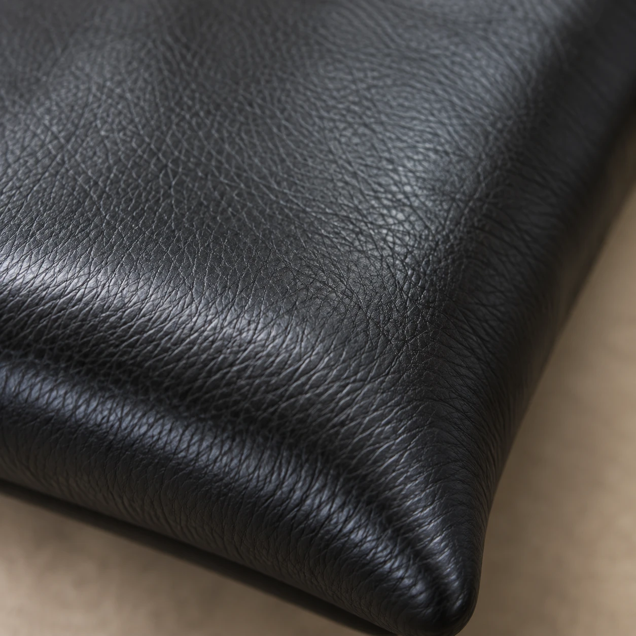 A black leather swatch with a fine, even, smooth grain