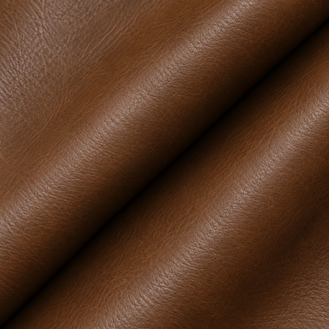 A close view of smooth brown upholstery leather folded into a soft diagonal roll