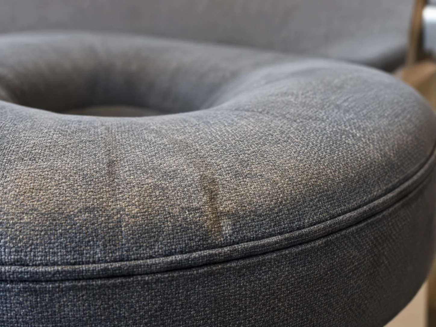 Soiled and scuffed round seat cushion on a waiting room chair