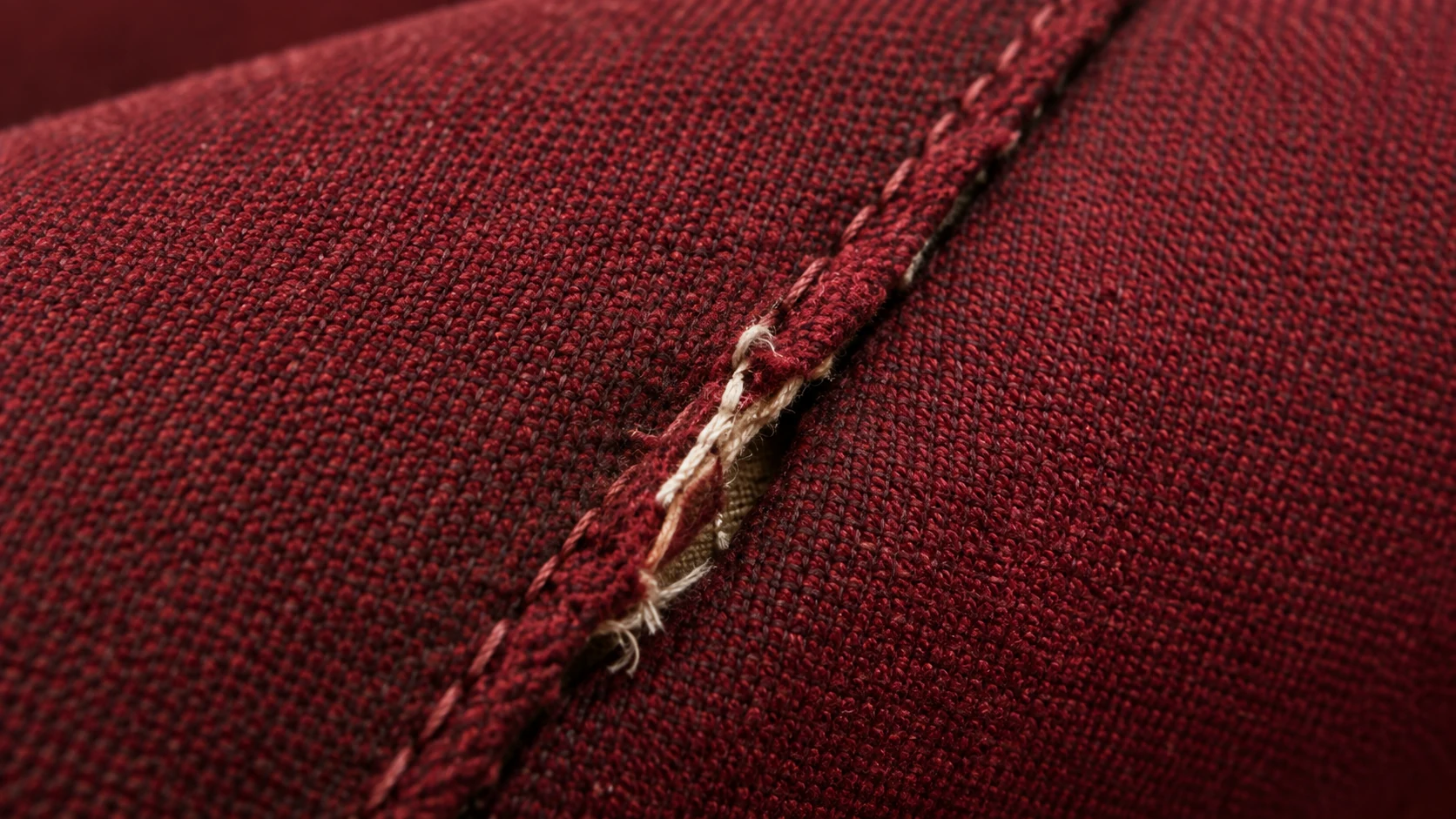 Auditorium seat cover split at the seam with filling showing