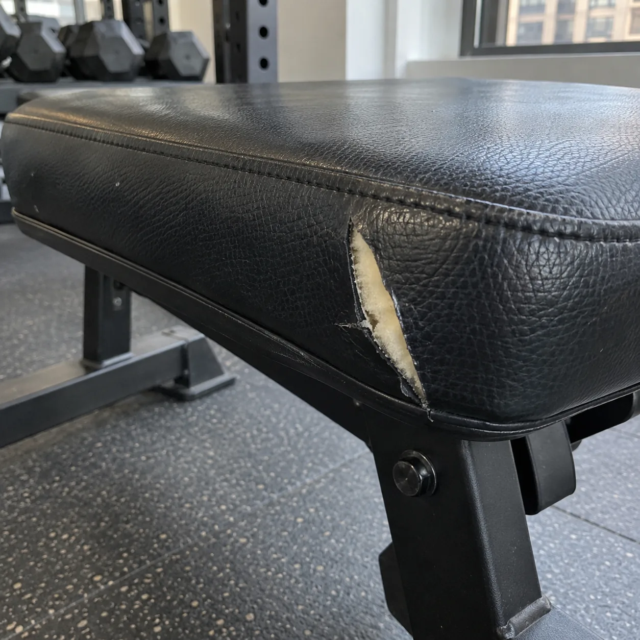 A black vinyl gym bench split along the edge