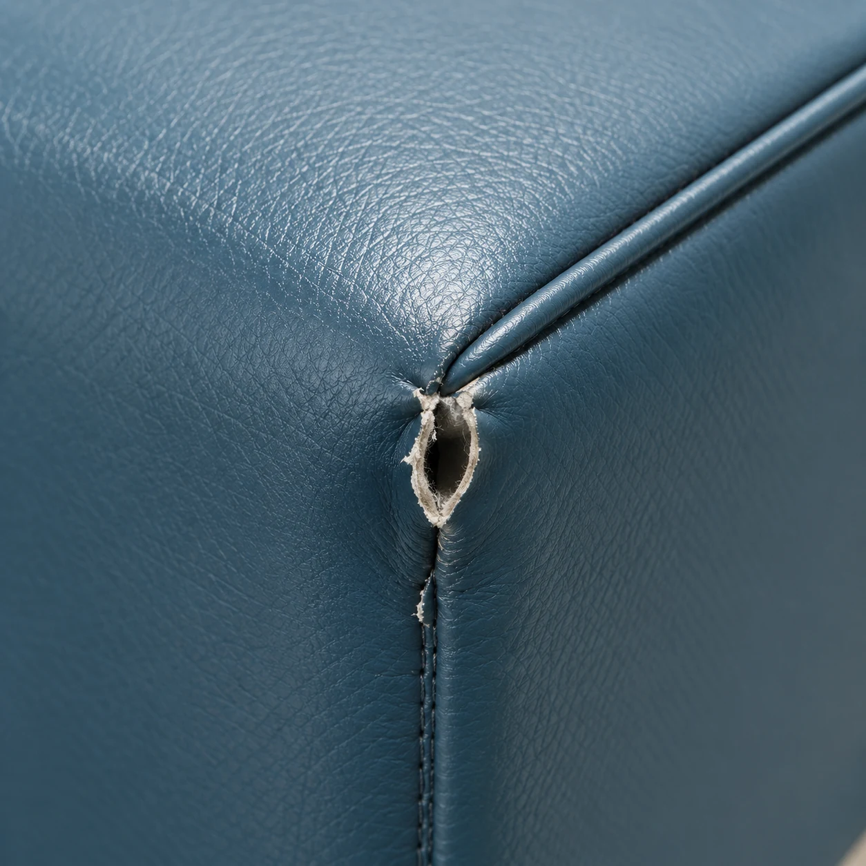Vinyl split open where two seams meet on a treatment chair cushion
