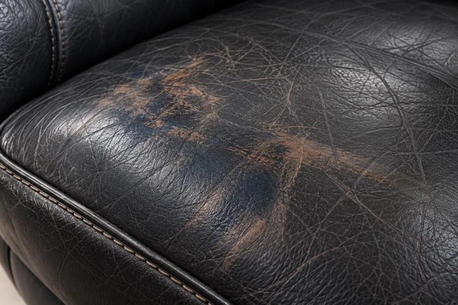 Close-up of brown dye transferred onto a black leather seat cushion