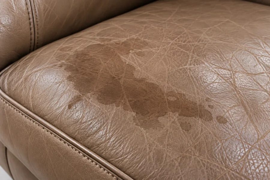 Close-up of a pale water mark and tide line on a taupe leather cushion