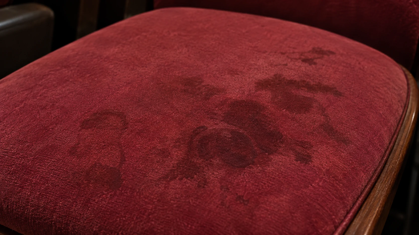 Dark stains on a burgundy theater seat